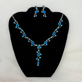 Jewelry set with blue floral necklace and earrings on a black stand.