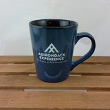 Blue mug with Adirondack Experience logo on a wooden surface