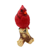 Red cardinal bird figurine on a branch against a white background