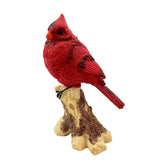 Red cardinal bird figurine on a branch against a white background