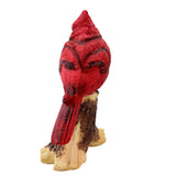 Red cardinal bird figurine on a branch against a white background