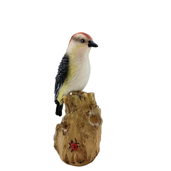 Woodpecker figurine on a wooden stump with a ladybug, against a white background
