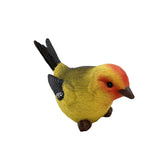 Colorful bird figurine with yellow body, red head, and black wings on a white background