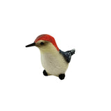 Figurine of a red-headed woodpecker on a white background